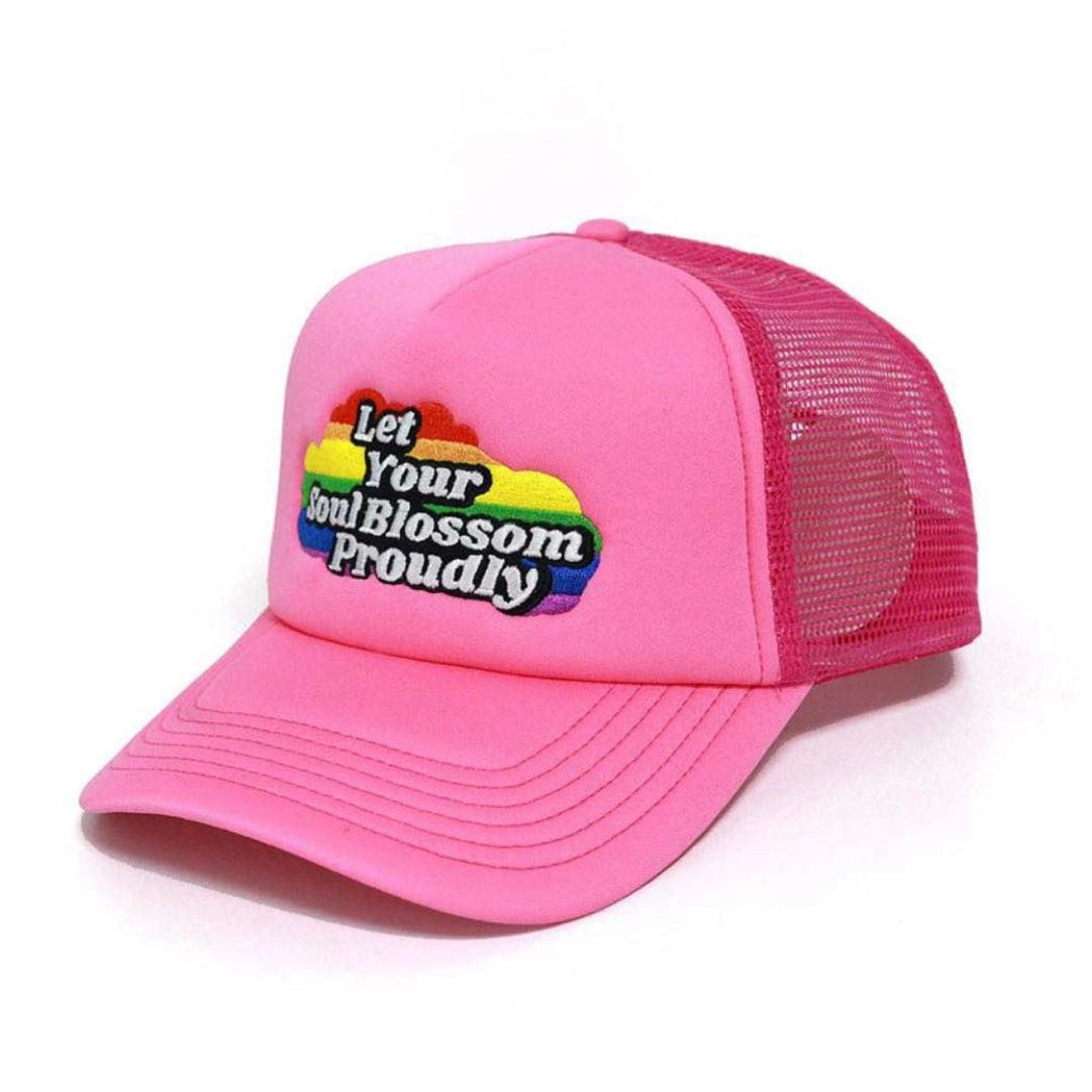 Rich pink foam LGBTQ+ trucker hat with a rainbow cloud that says let your soul blossom proudly on the front